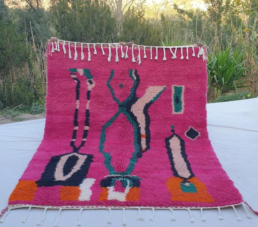 Pink Moroccan rug with geometric design and fringe border